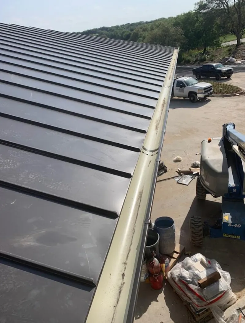 Standing seam panel and gutter detail on a metal roofing jobsite in Darien